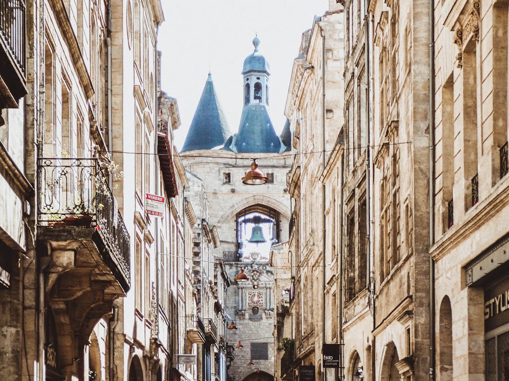 Charming city street view leading to an iconic bell tower, showcasing classic architecture.